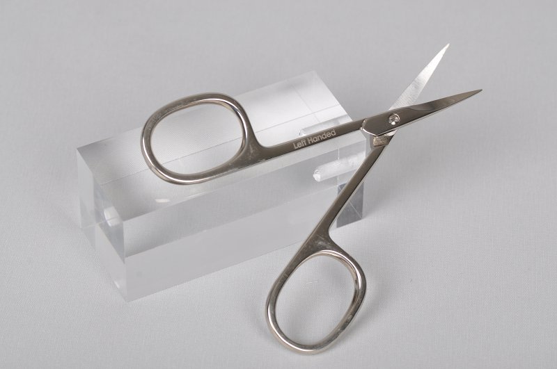 venstrehånds neglebåndssaks til en venstrehåndet person